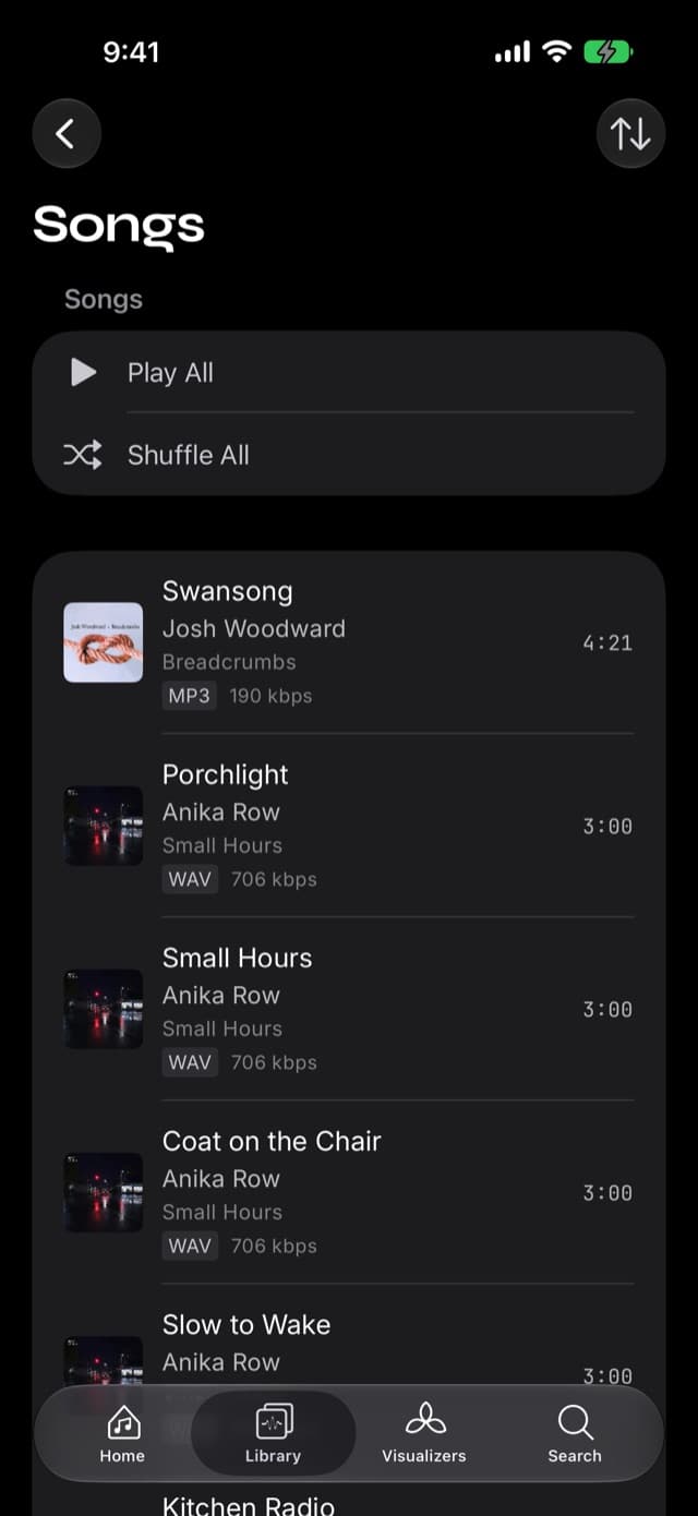 The Songs list in Prismatic Music showing codec and bitrate badges on each row